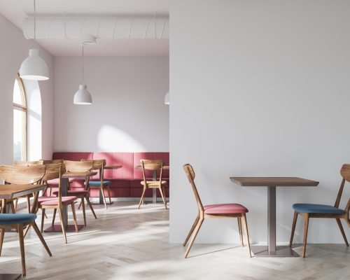 Modern white cafe interior with a wooden floor, a bar with stools and square tables with blue chairs near them. Soft red sofas along the walls. A side view 3d rendering mock up